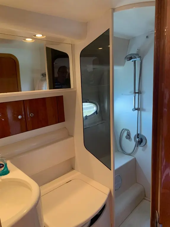 Compact bathroom with shower, sink, and toilet. Mirrors and light fixtures enhance modern design. Clean and functional space.